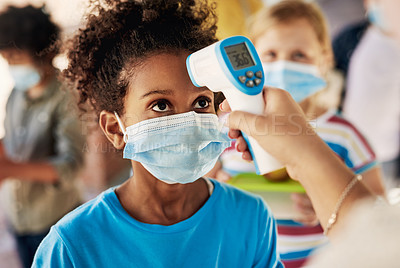 Buy stock photo Shot of a young girl wearing a mask and getting her temperature checked before going out to play during recess