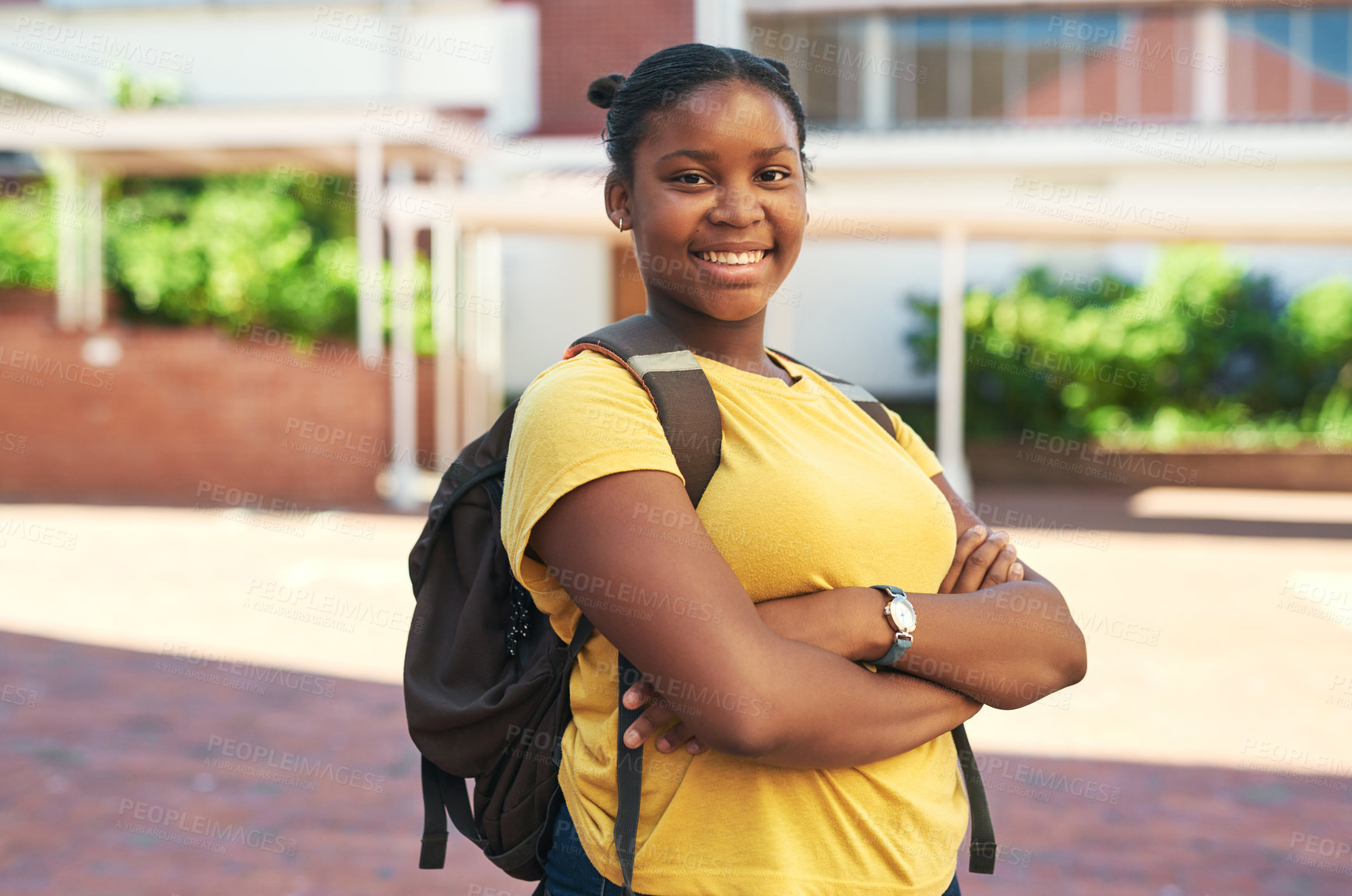 Buy stock photo Shot of a young girl standing alone outside with her arms folded during a day at school