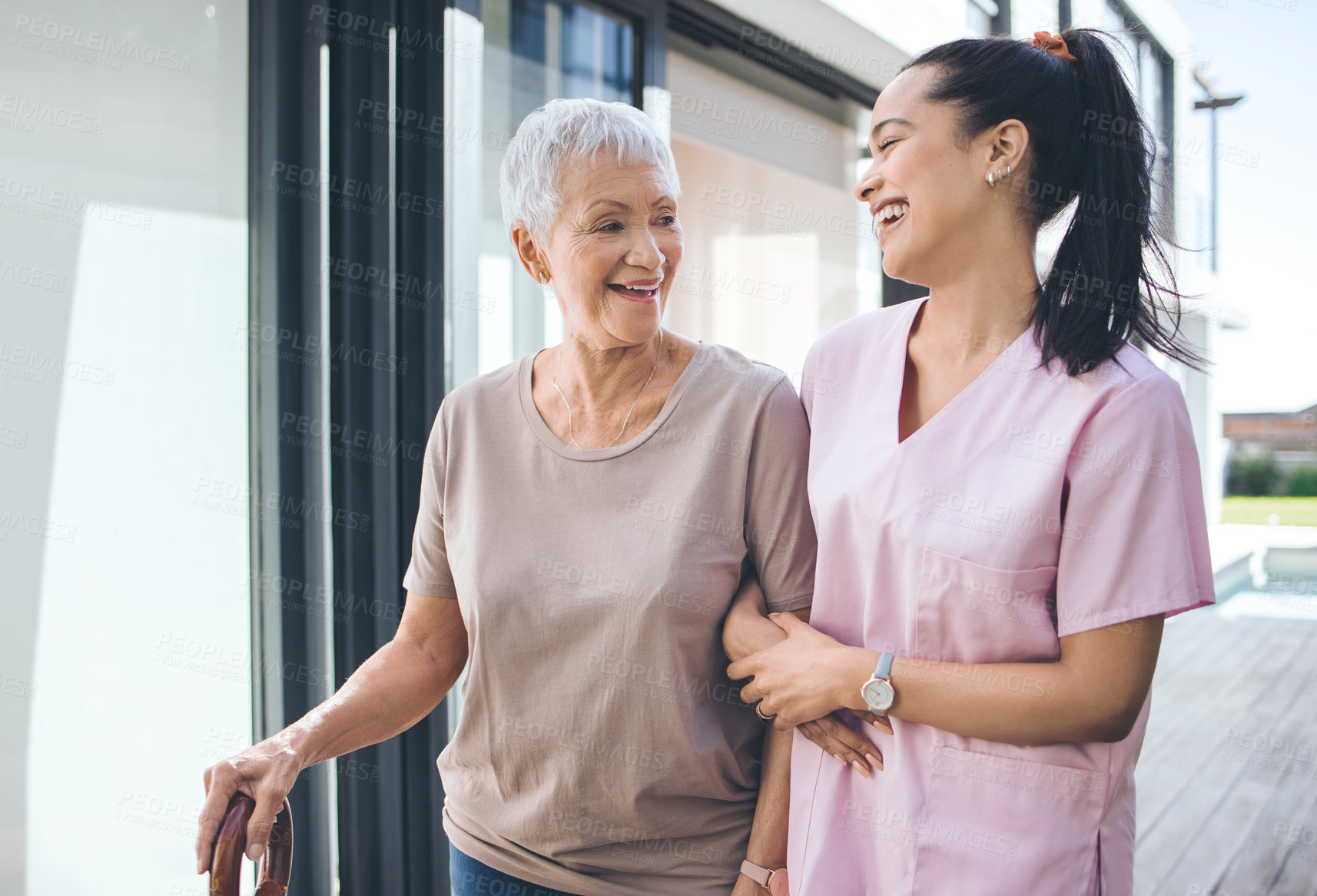 Buy stock photo Shot of an older woman using a walking stick and walking with the assistance of a physiotherapist