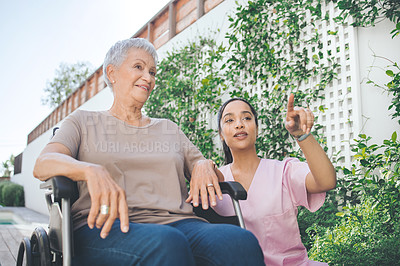 Buy stock photo Shot of a young nurse caring for an older woman in a wheelchair
