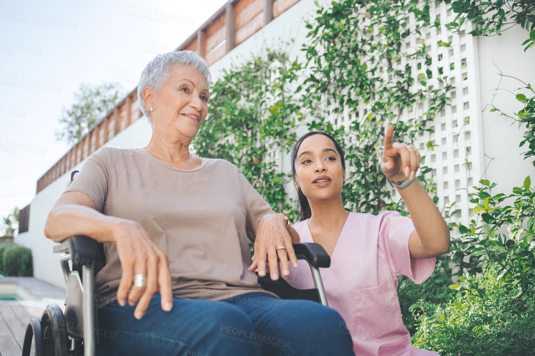 Buy stock photo Shot of a young nurse caring for an older woman in a wheelchair