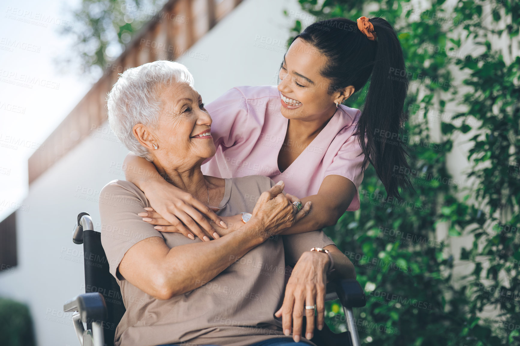 Buy stock photo Shot of a young nurse caring for an older woman in a wheelchair