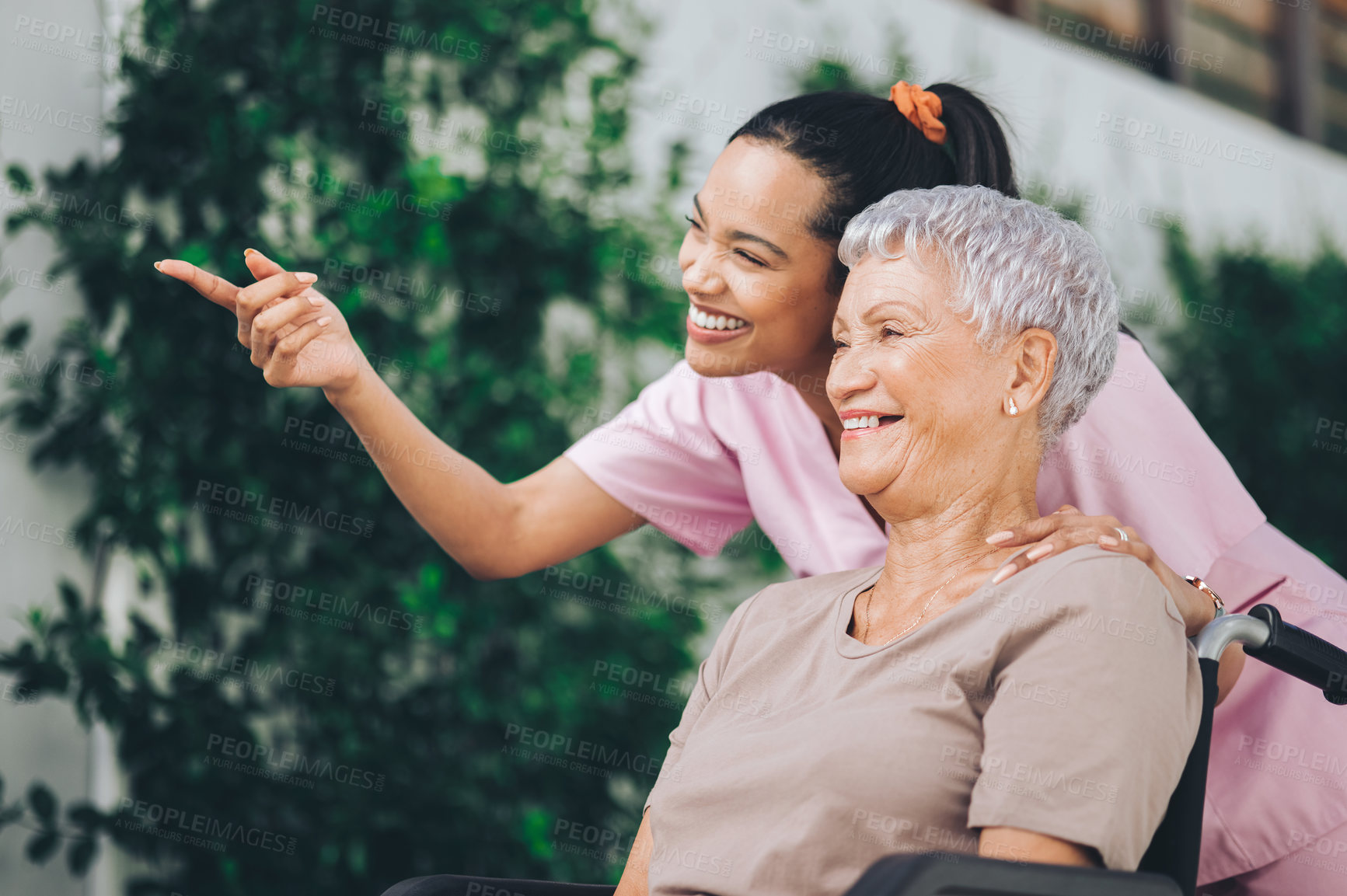 Buy stock photo Shot of a young nurse caring for an older woman in a wheelchair