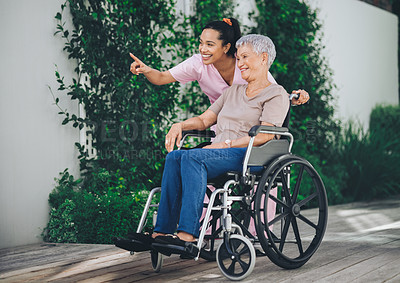 Buy stock photo Shot of a young nurse caring for an older woman in a wheelchair