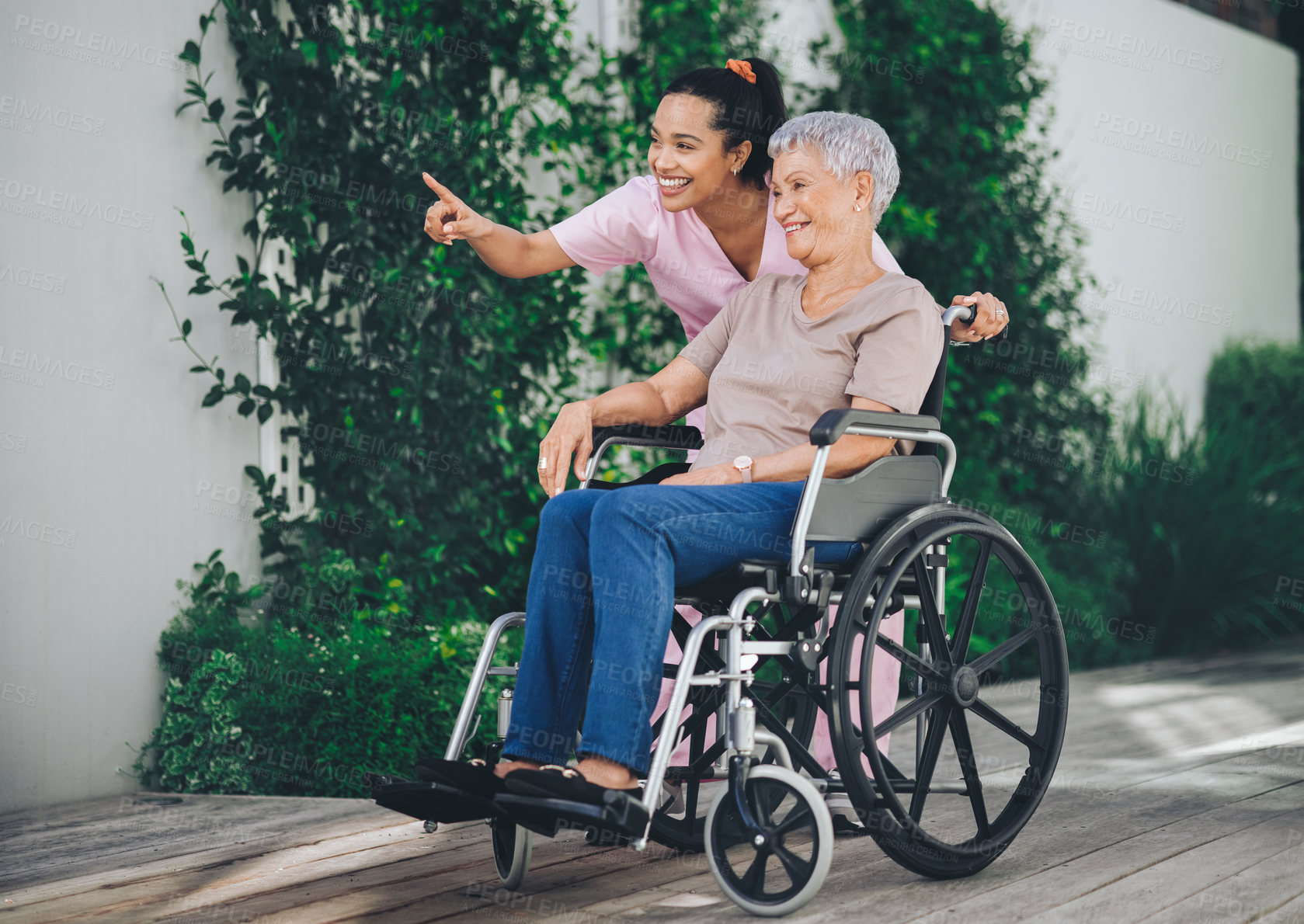 Buy stock photo Shot of a young nurse caring for an older woman in a wheelchair