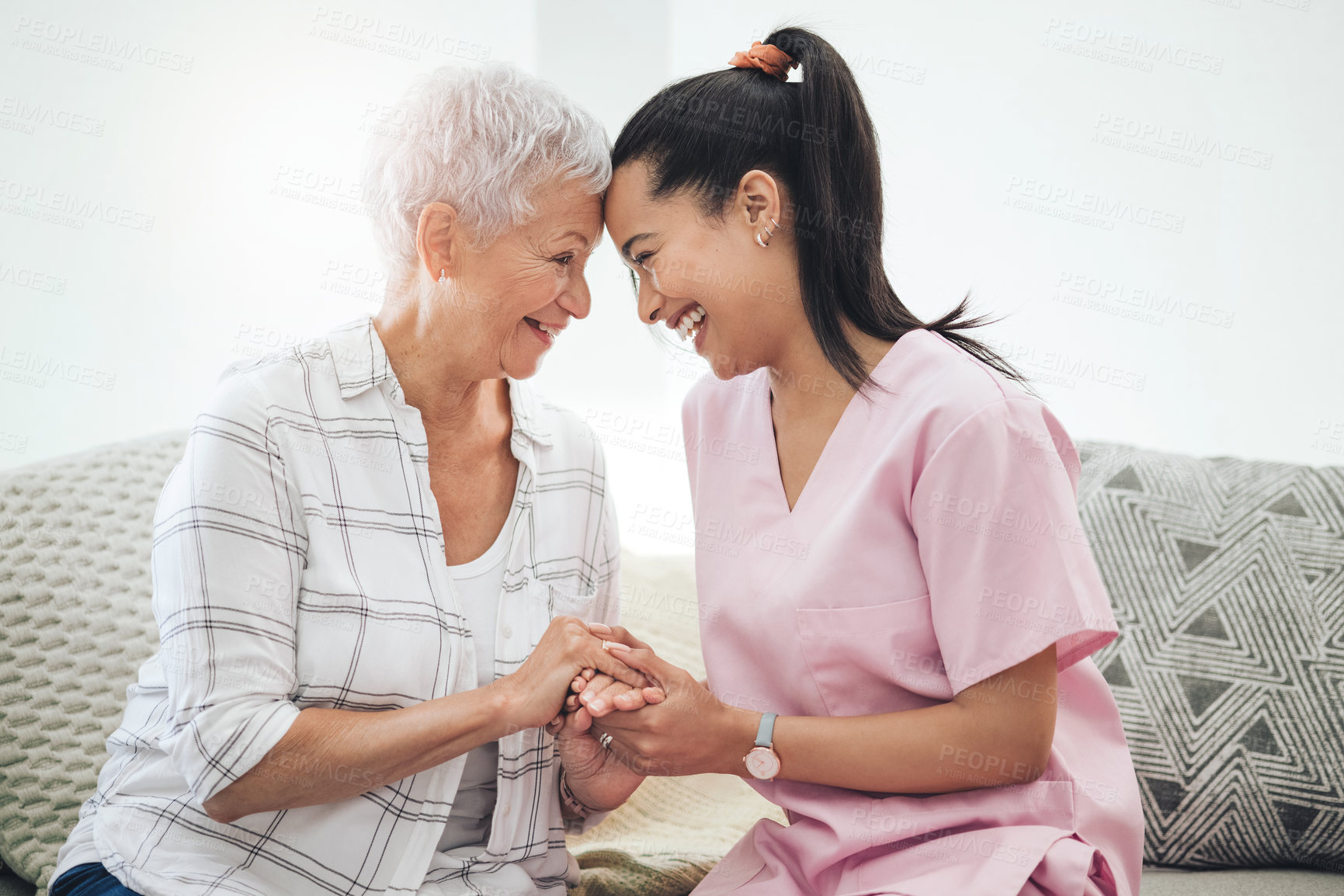 Buy stock photo Shot of a young nurse caring for an older woman inside