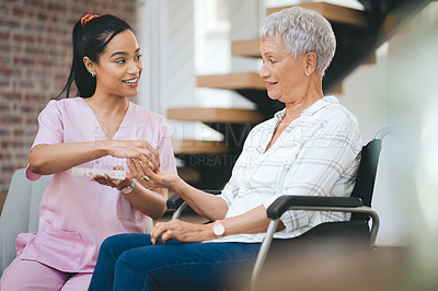 Buy stock photo Shot of a young nurse caring for an older woman in a wheelchair