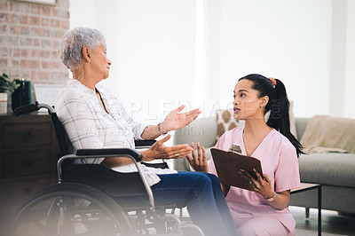 Buy stock photo Shot of a young nurse talking to an older woman in a wheelchair