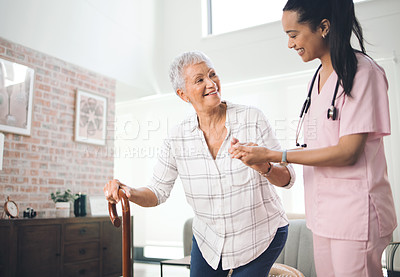 Buy stock photo Shot of an older woman using a walking stick and walking with the assistance of a physiotherapist