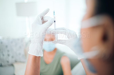 Buy stock photo Closeup shot of an unrecognizable doctor checking the syringe before injecting her patient