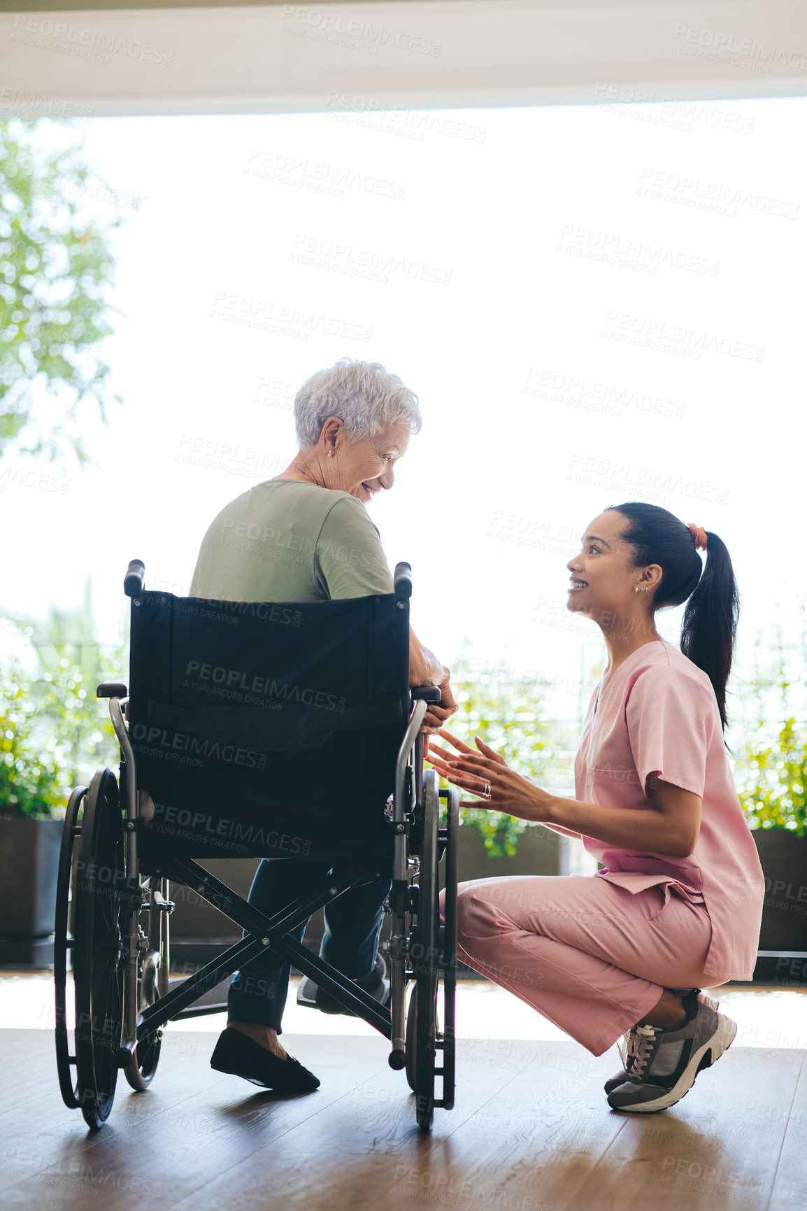 Buy stock photo Shot of a young nurse caring for an older woman in a wheelchair