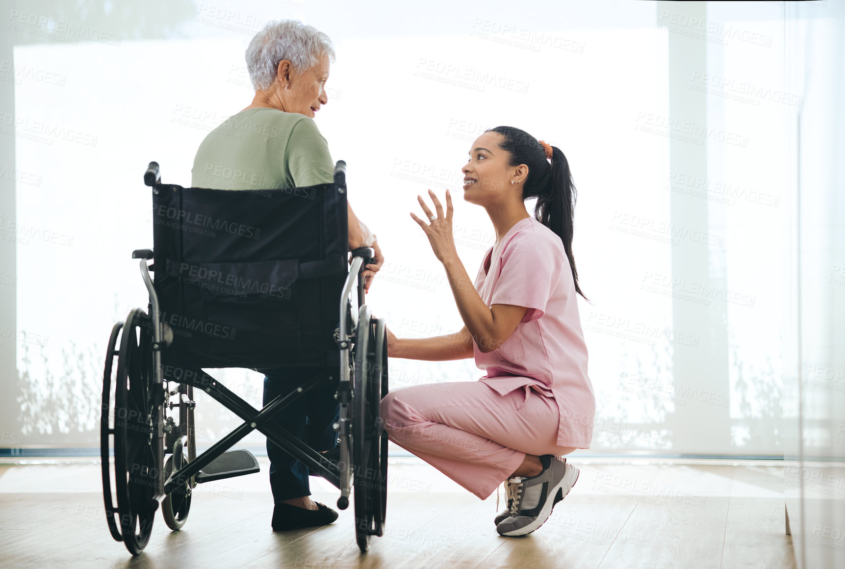 Buy stock photo Shot of a young nurse caring for an older woman in a wheelchair