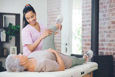 Buy stock photo Shot of an older woman doing light exercises during a session with a physiotherapist inside