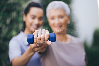 Buy stock photo Shot of an older woman lifting a dumbbell during a session with a physiotherapist
