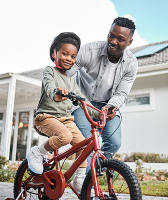 Buy stock photo Portrait of an adorable boy learning to ride a bicycle with his father outdoors