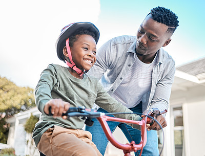 Buy stock photo Shot of a father teaching his son to ride a bicycle outdoors