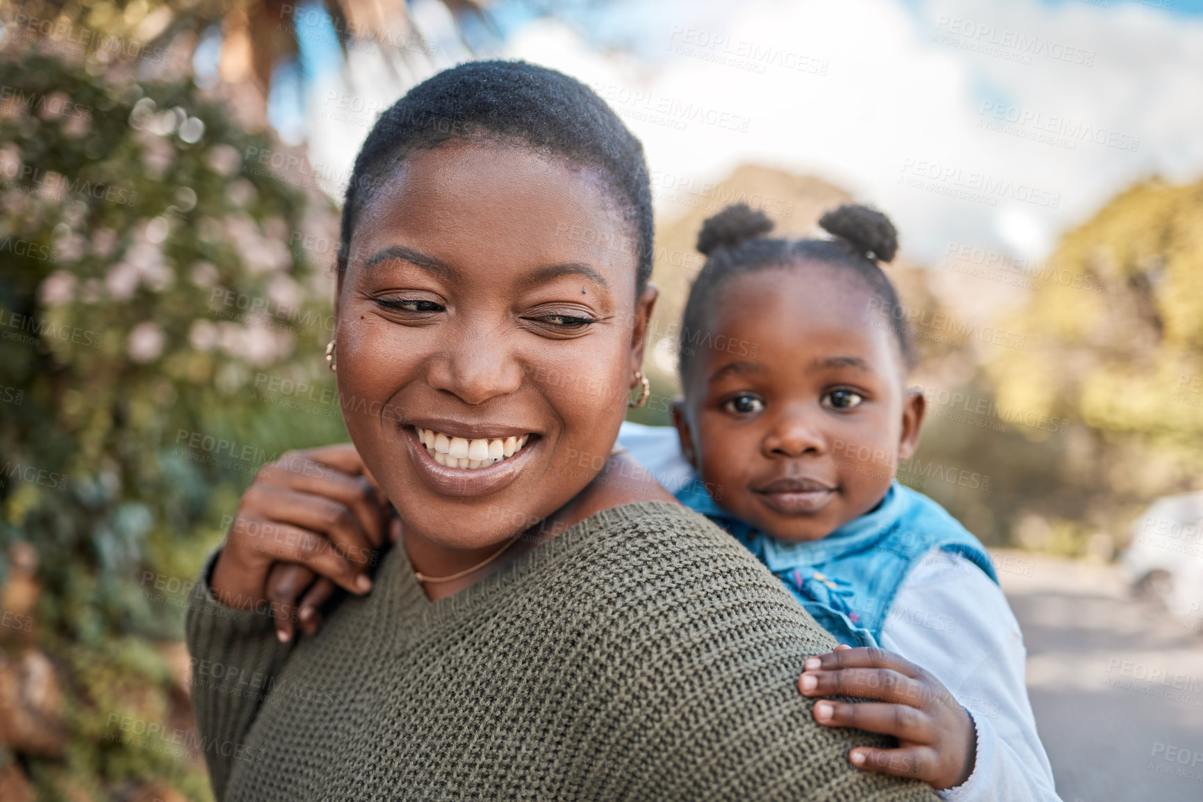 Buy stock photo Shot of a mother giving her daughter a piggyback ride outdoors