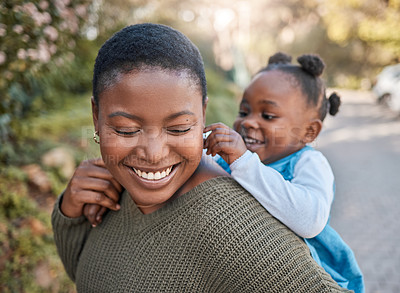 Buy stock photo Shot of a mother giving her daughter a piggyback ride outdoors