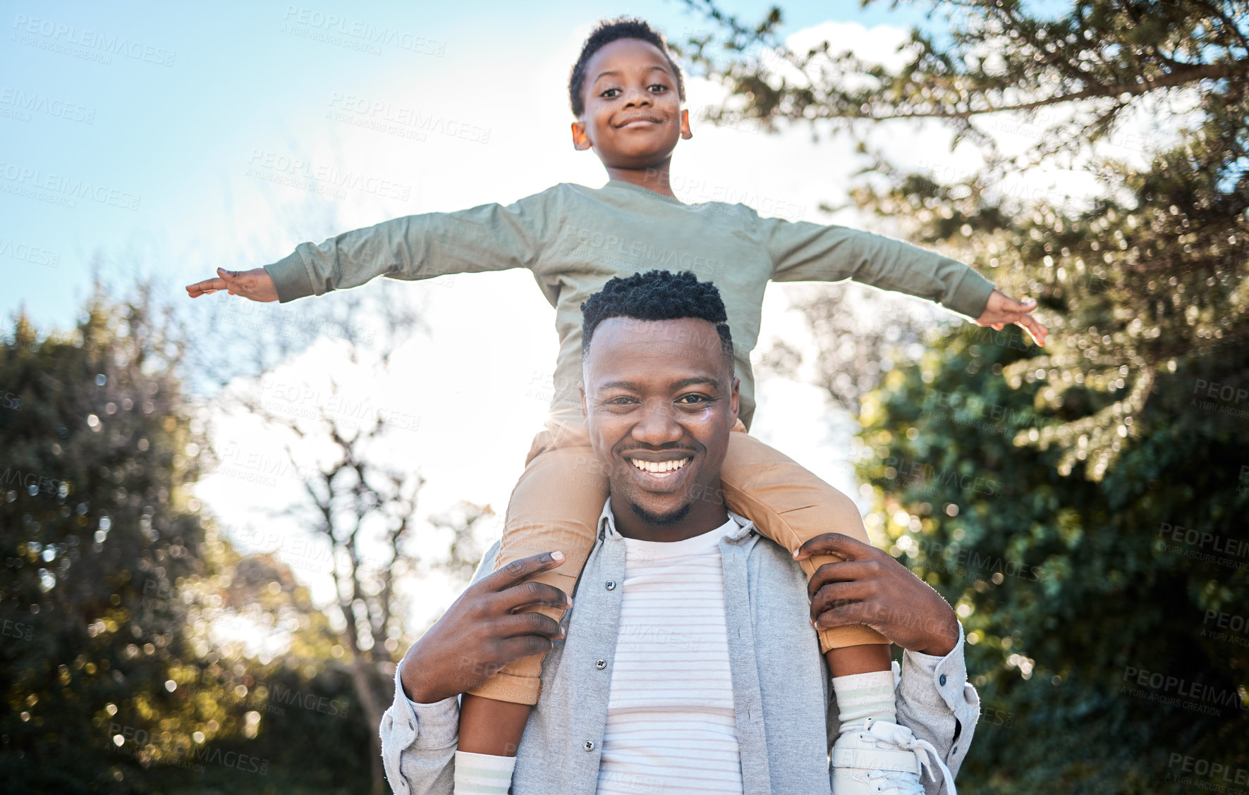 Buy stock photo Portrait of a father carrying his son on his shoulders outdoors