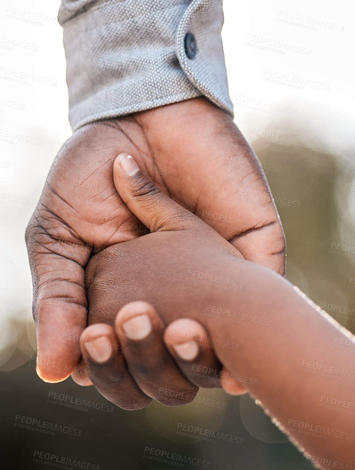 Buy stock photo Closeup shot of a father holding his son's hand while walking together outdoors