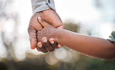 Buy stock photo Closeup shot of a father holding his son's hand while walking together outdoors