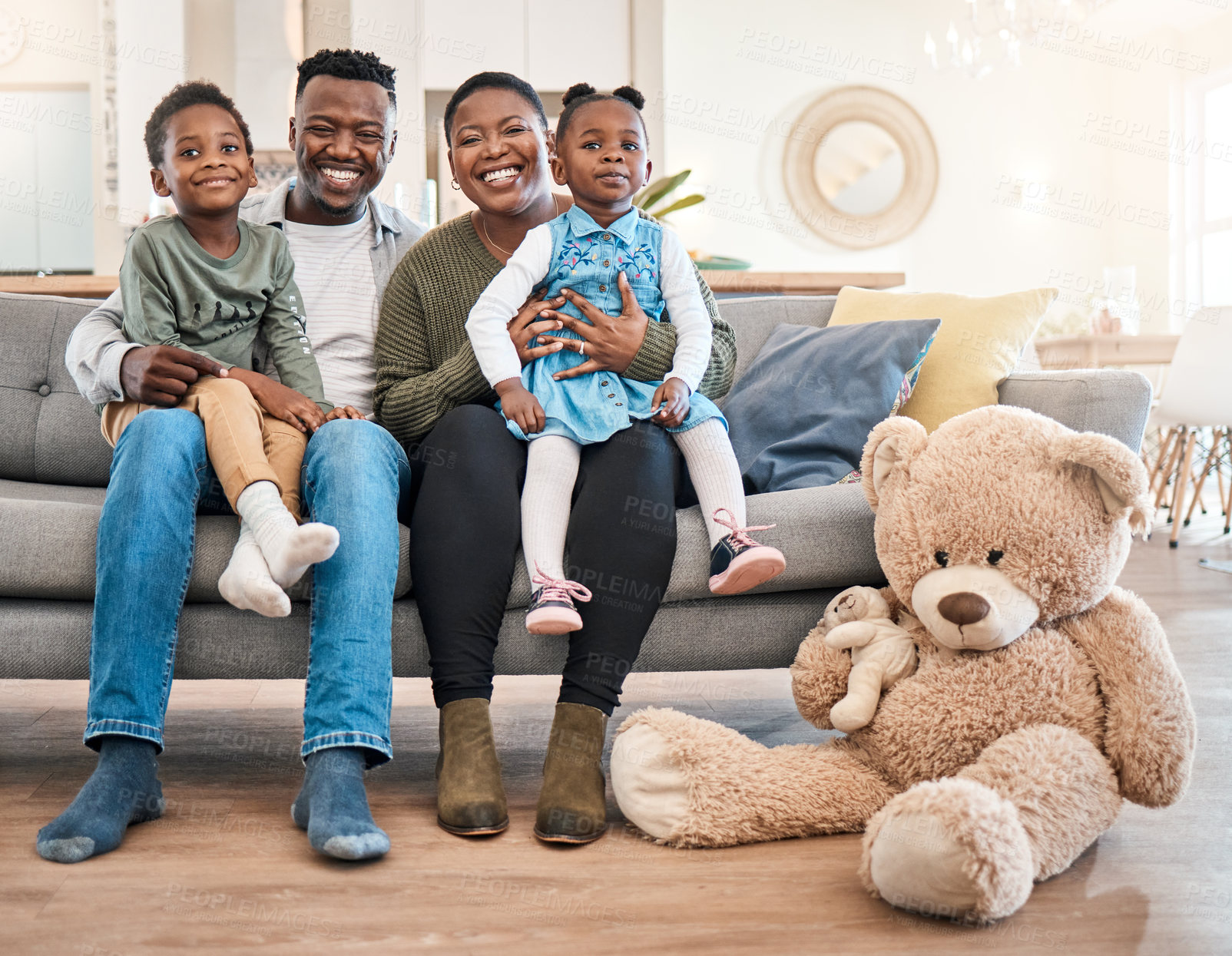 Buy stock photo Portrait of a happy young family relaxing on the sofa at home
