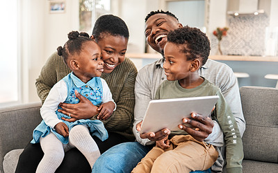 Buy stock photo Shot of a happy young family using a digital tablet on the sofa at home