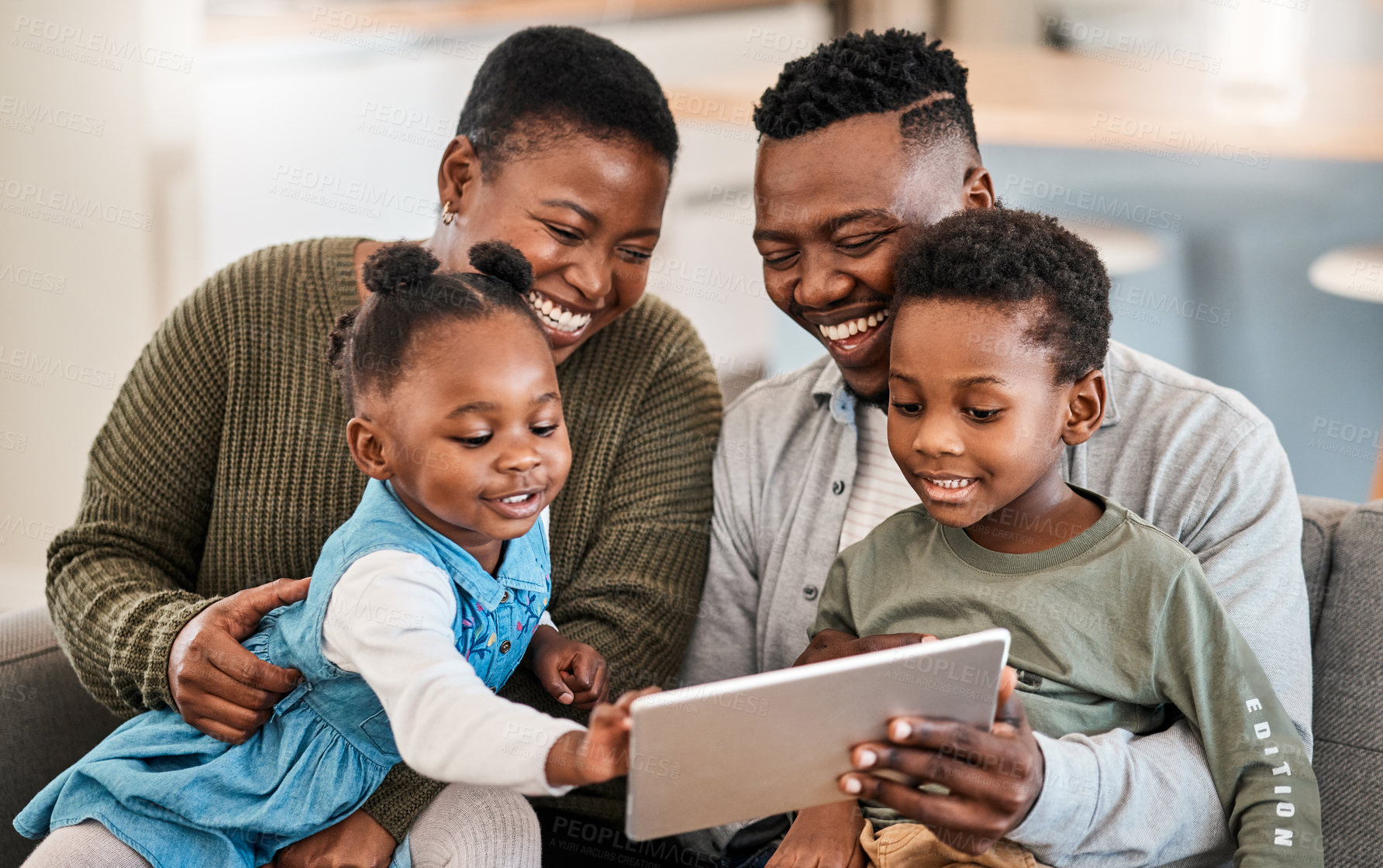 Buy stock photo Shot of a happy young family using a digital tablet on the sofa at home