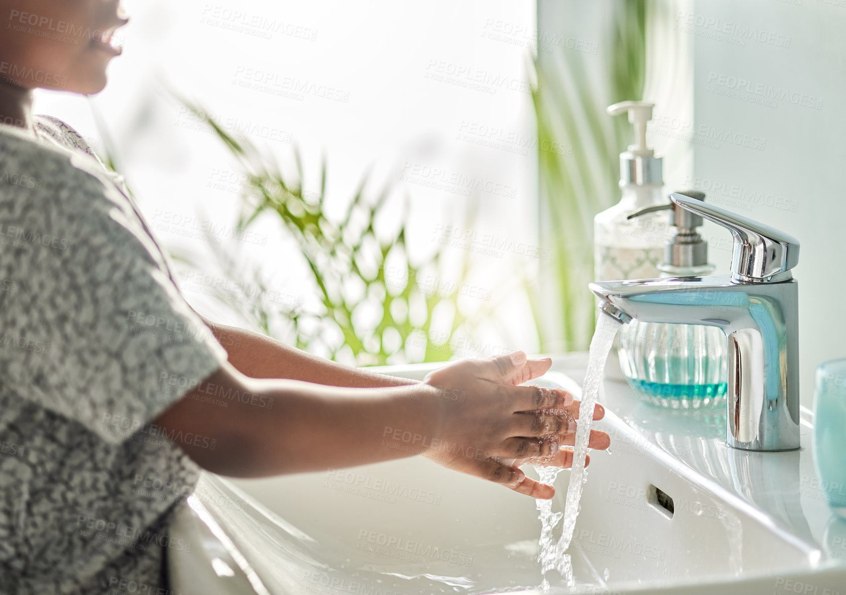 Buy stock photo Closeup shot of an unrecognisable boy washing his hands at a tap in a bathroom at home