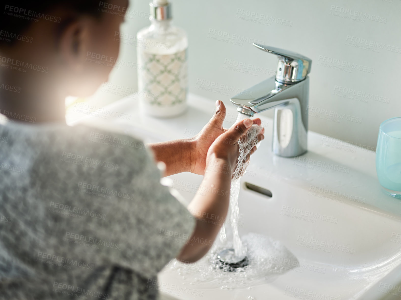 Buy stock photo Closeup shot of an unrecognisable boy washing his hands at a tap in a bathroom at home