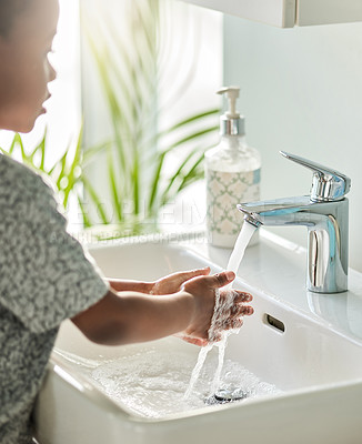 Buy stock photo Closeup shot of an unrecognisable boy washing his hands at a tap in a bathroom at home