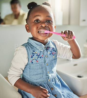 Buy stock photo Portrait of an adorable little girl brushing her teeth in the bathroom at home