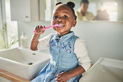 Buy stock photo Portrait of an adorable little girl brushing her teeth in the bathroom at home