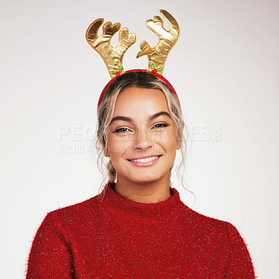 Buy stock photo Studio shot of a young woman wearing a reindeer headwear against a grey background