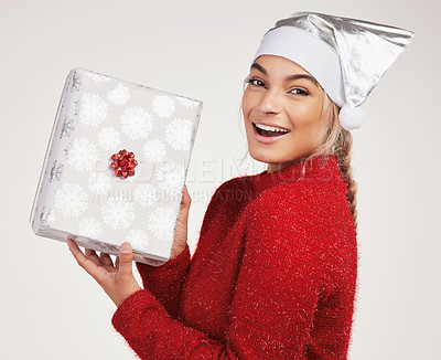 Buy stock photo Studio shot of a young woman holding a gift box against a grey background