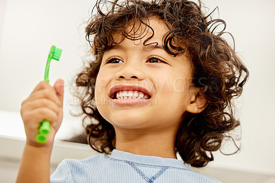 Buy stock photo Shot of a little boy brushing his teeth at home