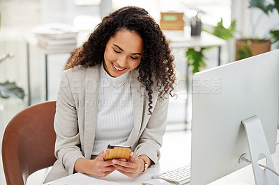 Buy stock photo Shot of a young businesswoman using a cellphone while working in an office