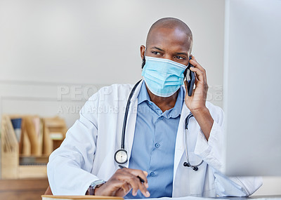 Buy stock photo Shot of a young doctor on a call while writing in a notebook at work