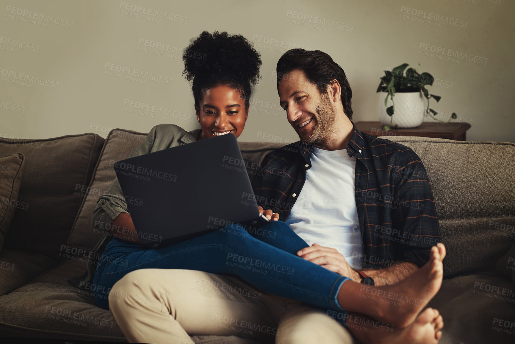 Buy stock photo Couple, relax and watch movie with laptop, online and romance in night, love and together on sofa in house. Digital, happy and embrace of woman with man, lounge and enjoyment in weekend in home