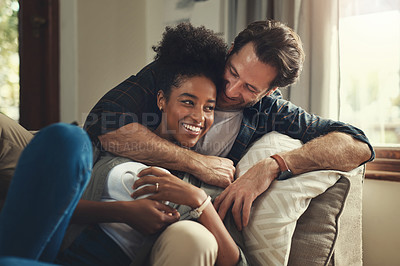 Buy stock photo Shot of a happy young couple relaxing on a couch in their living room at home