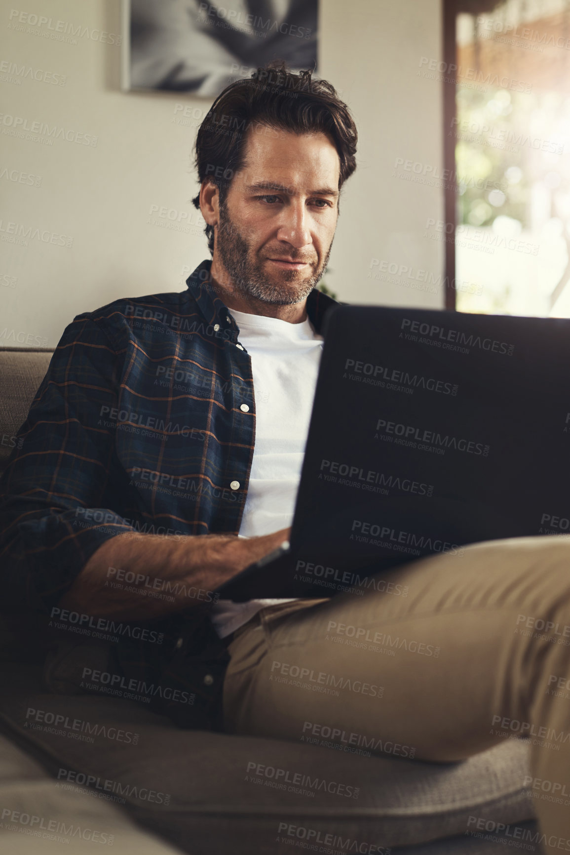 Buy stock photo Man, house and sofa with laptop for remote work as freelance writer and journalist for newspaper. Male person, editor and couch in living room for online research on website for headline story