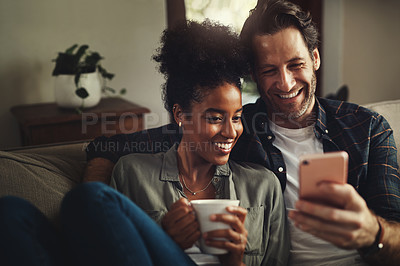 Buy stock photo Couple, smile and watch movie with cellphone, coffee and entertainment in morning and together on sofa in house. Digital, happy and love of woman with man, lounge and enjoyment in weekend in home