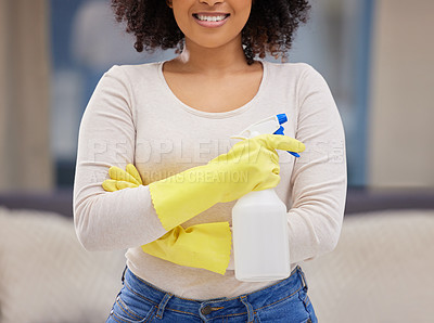 Buy stock photo Cropped shot of an unrecognizable woman standing alone at home and holding a spray bottle while doing her chores
