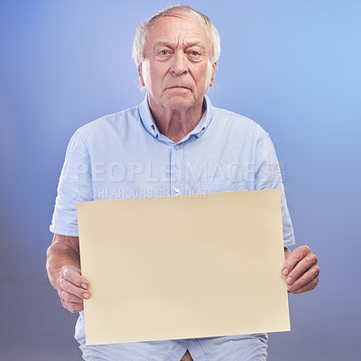 Buy stock photo Studio shot of a senior man holding a blank sign against a blue background