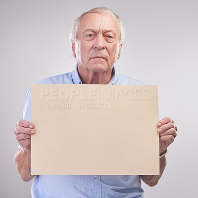 Buy stock photo Studio shot of a senior man holding a blank sign against a grey background