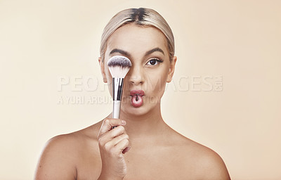 Buy stock photo Studio shot of a beautiful young woman holding up a make-up brush
