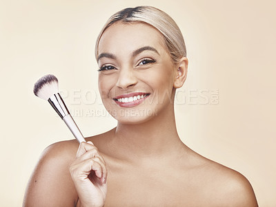 Buy stock photo Studio shot of a beautiful young woman holding up a make-up brush