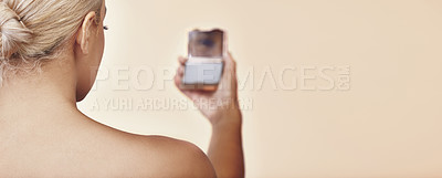 Buy stock photo Rearview shot of a woman looking into a pocket mirror