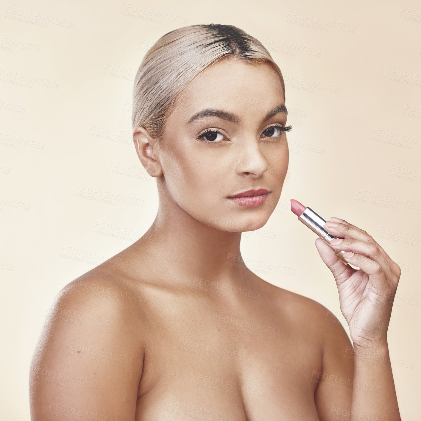 Buy stock photo Studio shot of a beautiful young woman applying pink lipstick