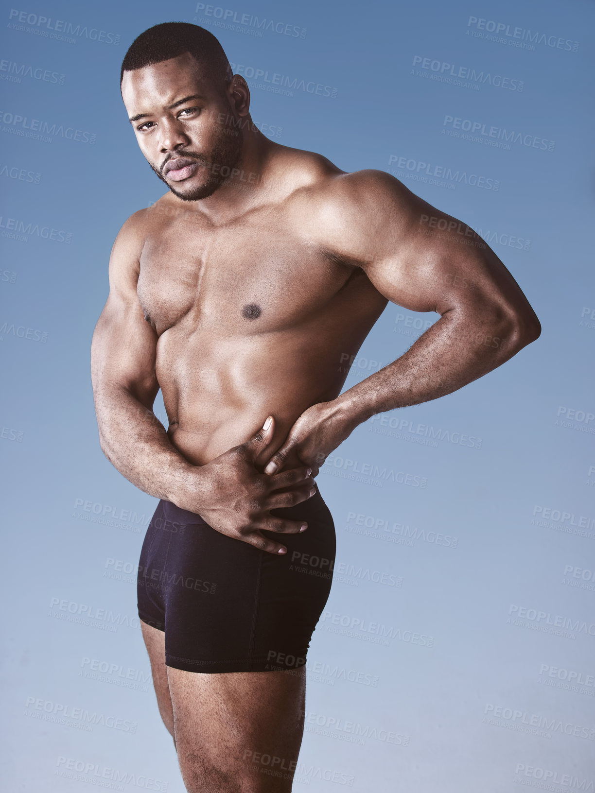 Buy stock photo Bodybuilder, fitness and black man in studio portrait, strong and wellness on blue background. Male person, underwear and body for results of exercise or workout, athlete and boxers for training